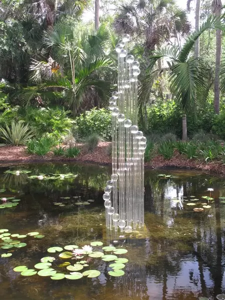 Lush paradise with water lilies galore, rustling bamboo, stone bridge, tropical flowers, strangler fig, and a gorgeous royal palm grove.