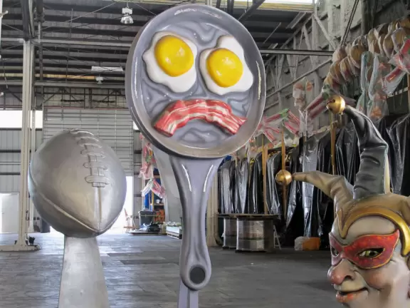 Mischievous face sculpture, football, pan with bacon and eggs.
