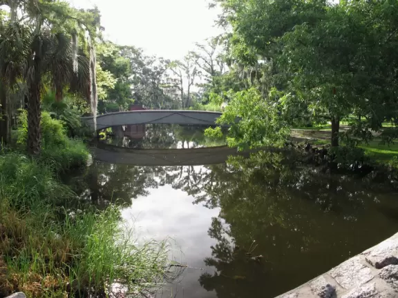 Beautiful park with stone bridges over a bayou and gigantic moss-draped oaks.